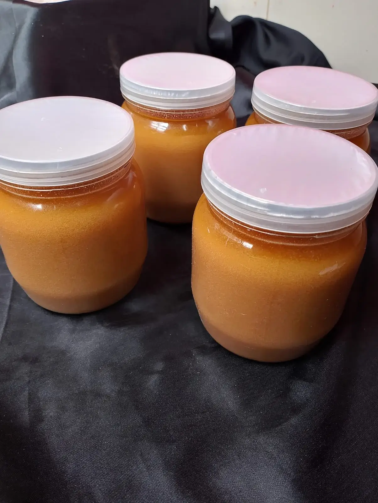 FreshPalli Danadar Ghee jars arranged on black fabric background